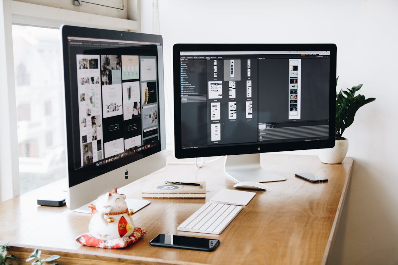 An image of a computer desk with two screens - could this be you building your first website?