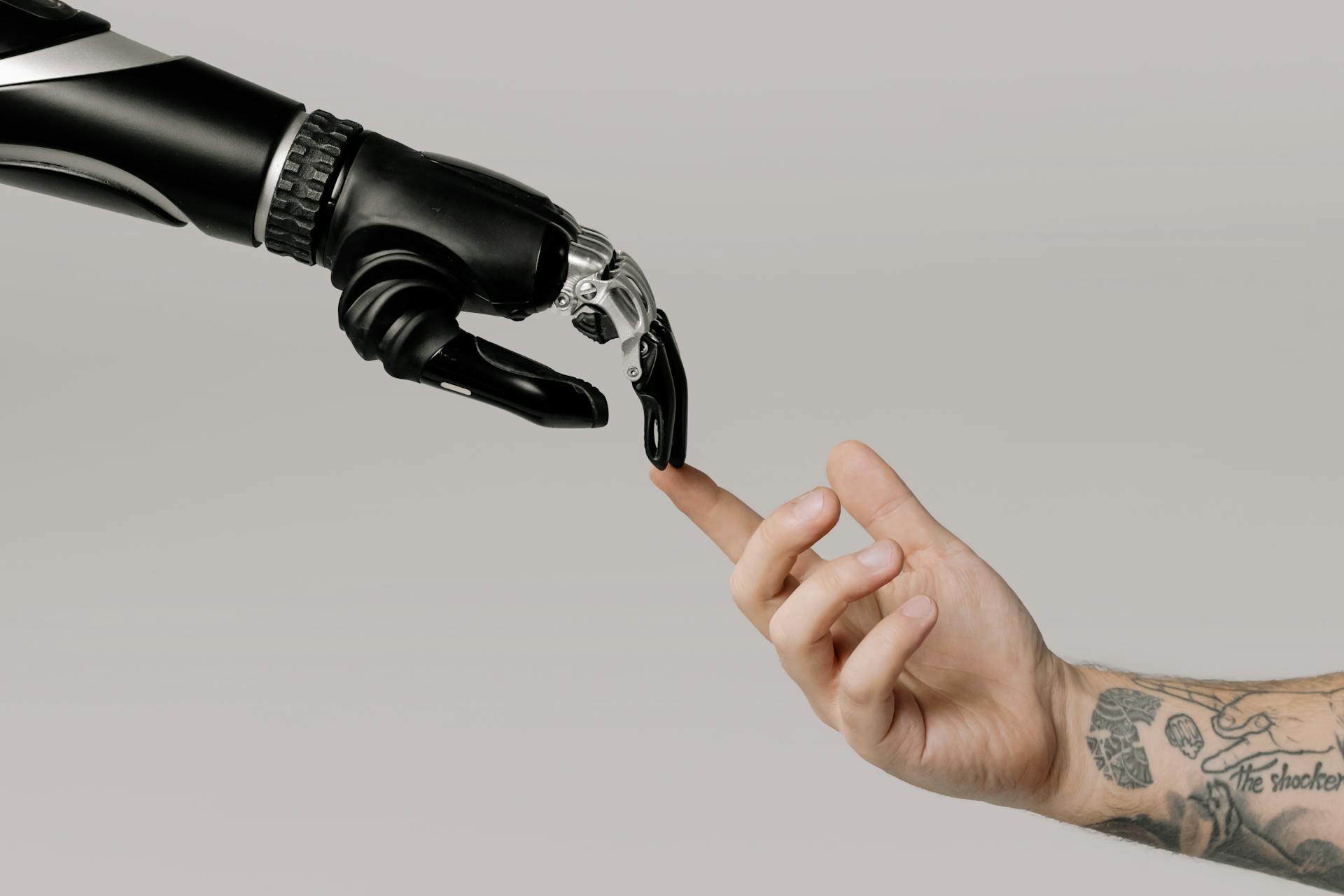 A picture of a robot hand reaching out to a human hand - whilst helpful, AI can't fix your website problems