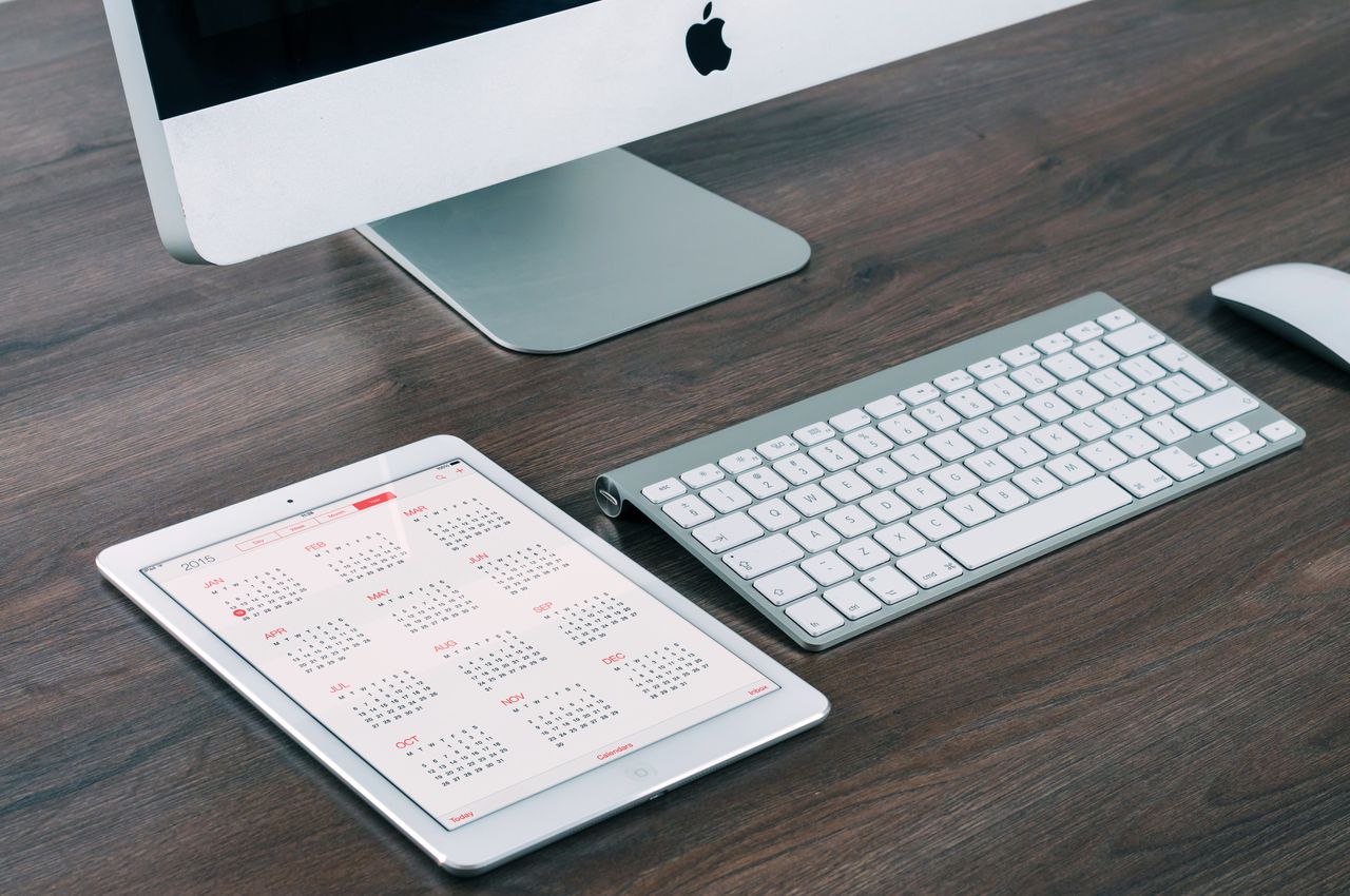 Picture of a calendar on a tablet next to an Apple computer - to introduce The Events Calendar; an amazing plugin on WordPress!